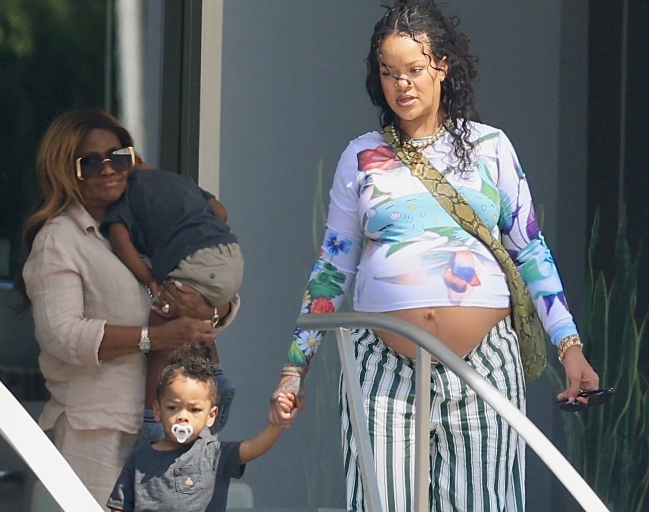 Rihanna sai na parte superior do camaleão azul de Chopova Lowena floral e com listras verdes Savage x Fenty calças com sua mãe e filhos Rza e Riot em Beverly Hills